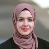 Mason assistant professor Doaa Bondok wears a mauve hijab and black suit in her faculty profile